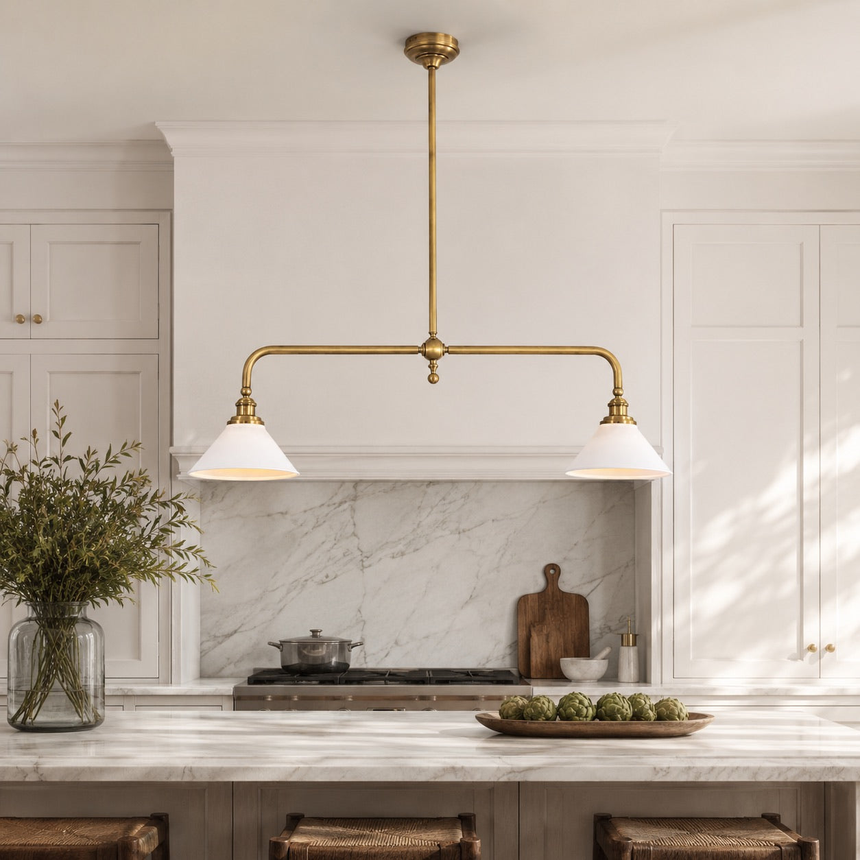 Modern linear pendant light with brass finish over a kitchen island