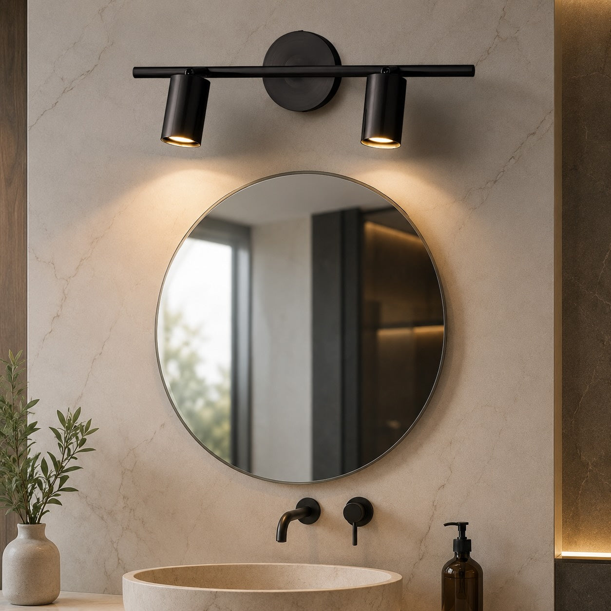 Brass rotatable spotlight wall sconce mounted beside a bathroom mirror