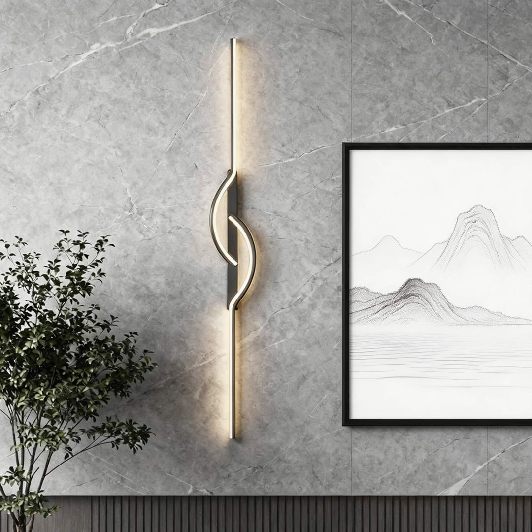 Tall black vertical LED wall sconce with centre wave detail and warm glow on marble wall, luxury wall light Australia