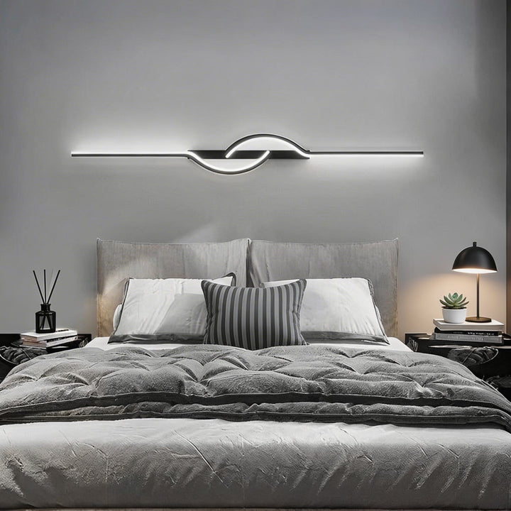 Long black horizontal LED wall sconce with centre loop accent above bed, modern bedroom wall light Australia