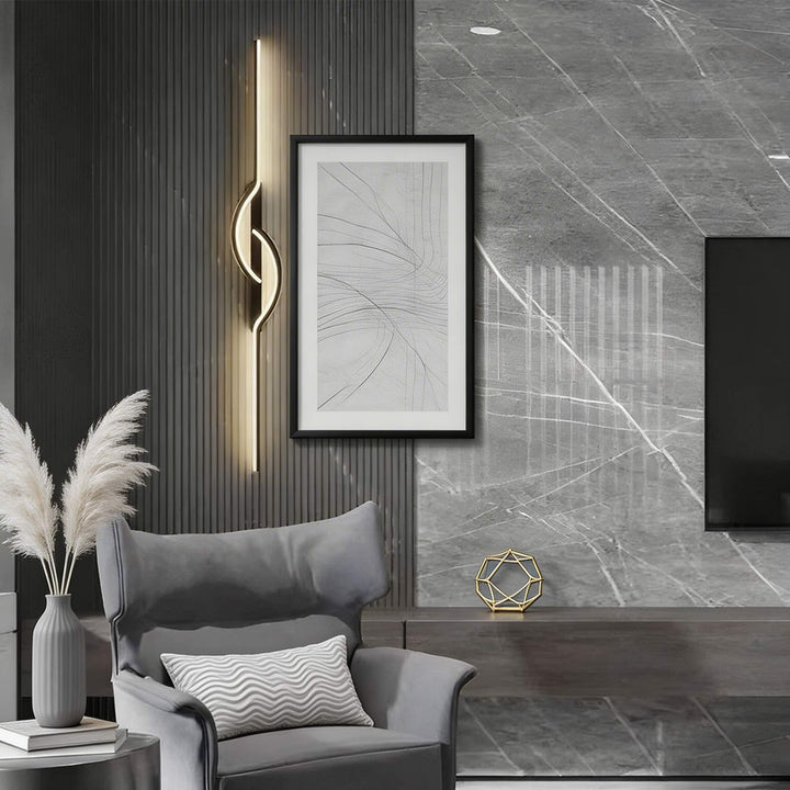 Tall gold vertical LED wall sconce with centre loop detail and warm glow on dark slat wall, luxury living room light Australia