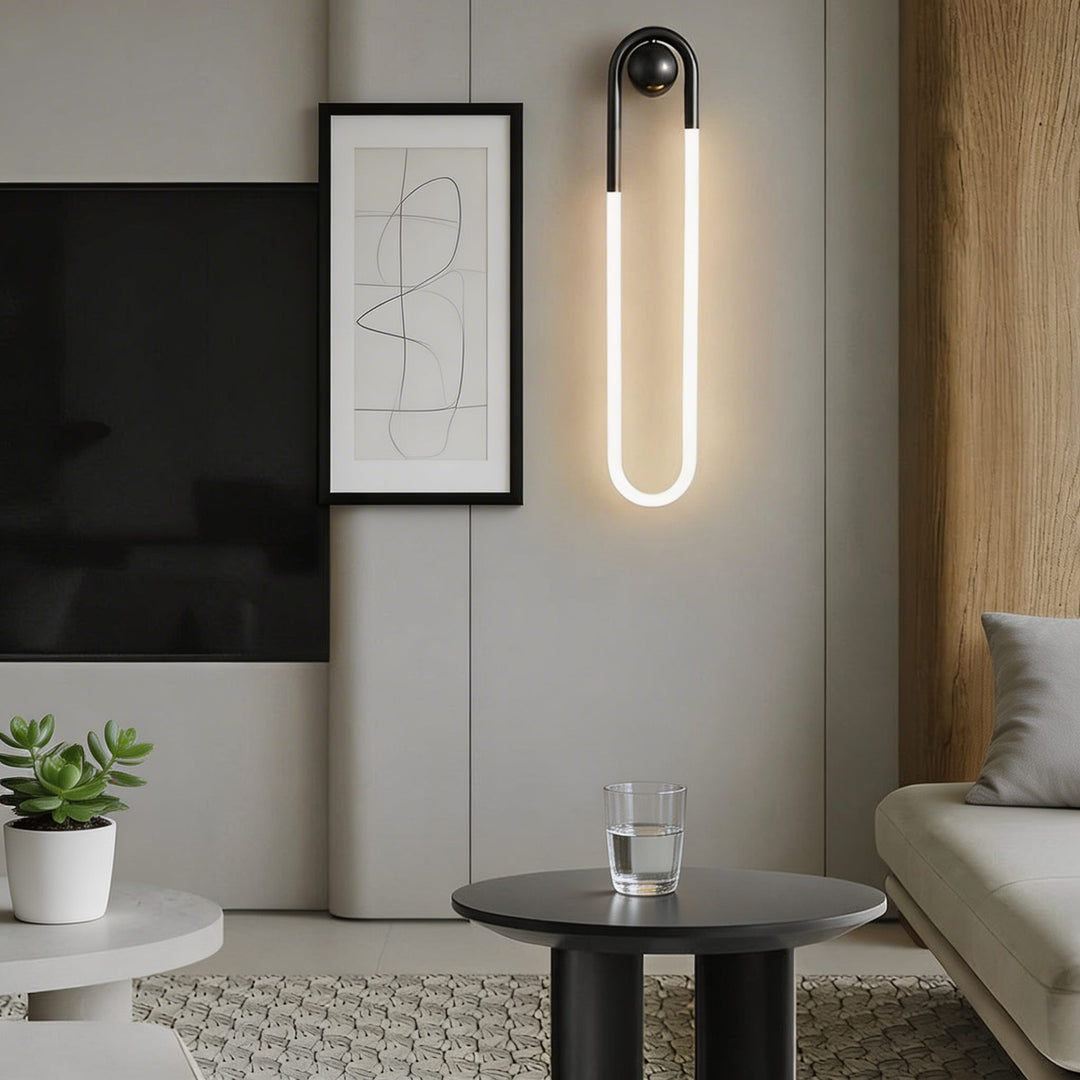Black U-shaped LED wall sconce with ball joint and warm white glow in modern living room, contemporary wall light Australia