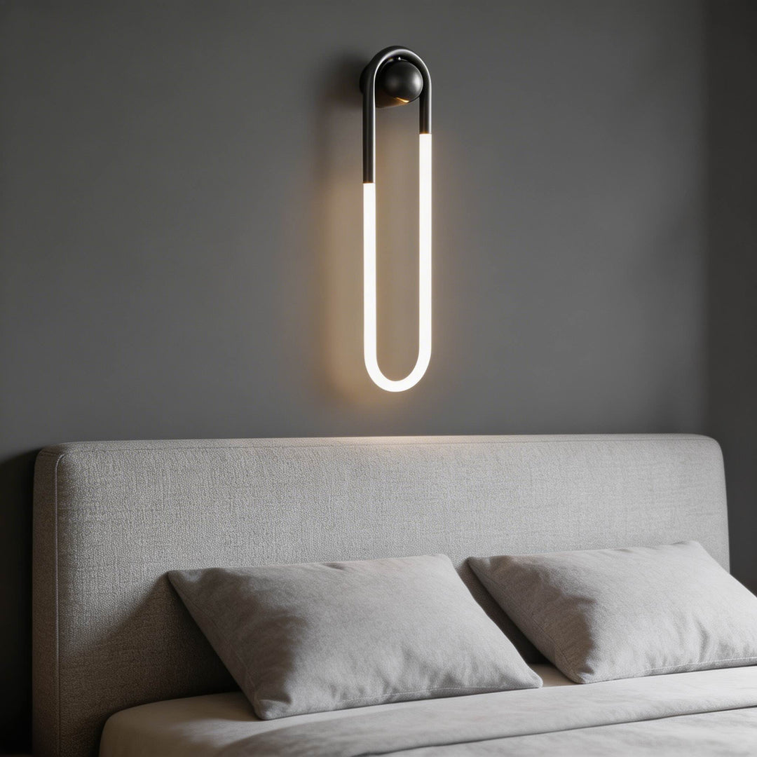Black U-shaped LED tube wall sconce with ball joint mount and warm white glow, designer bedside wall light Australia