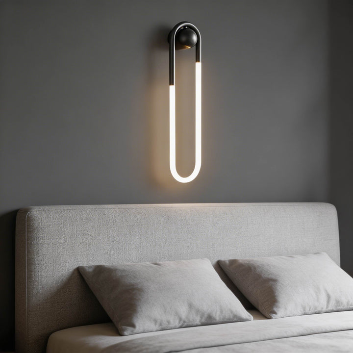 Black U-shaped LED tube wall sconce with ball joint mount and warm white glow, designer bedside wall light Australia