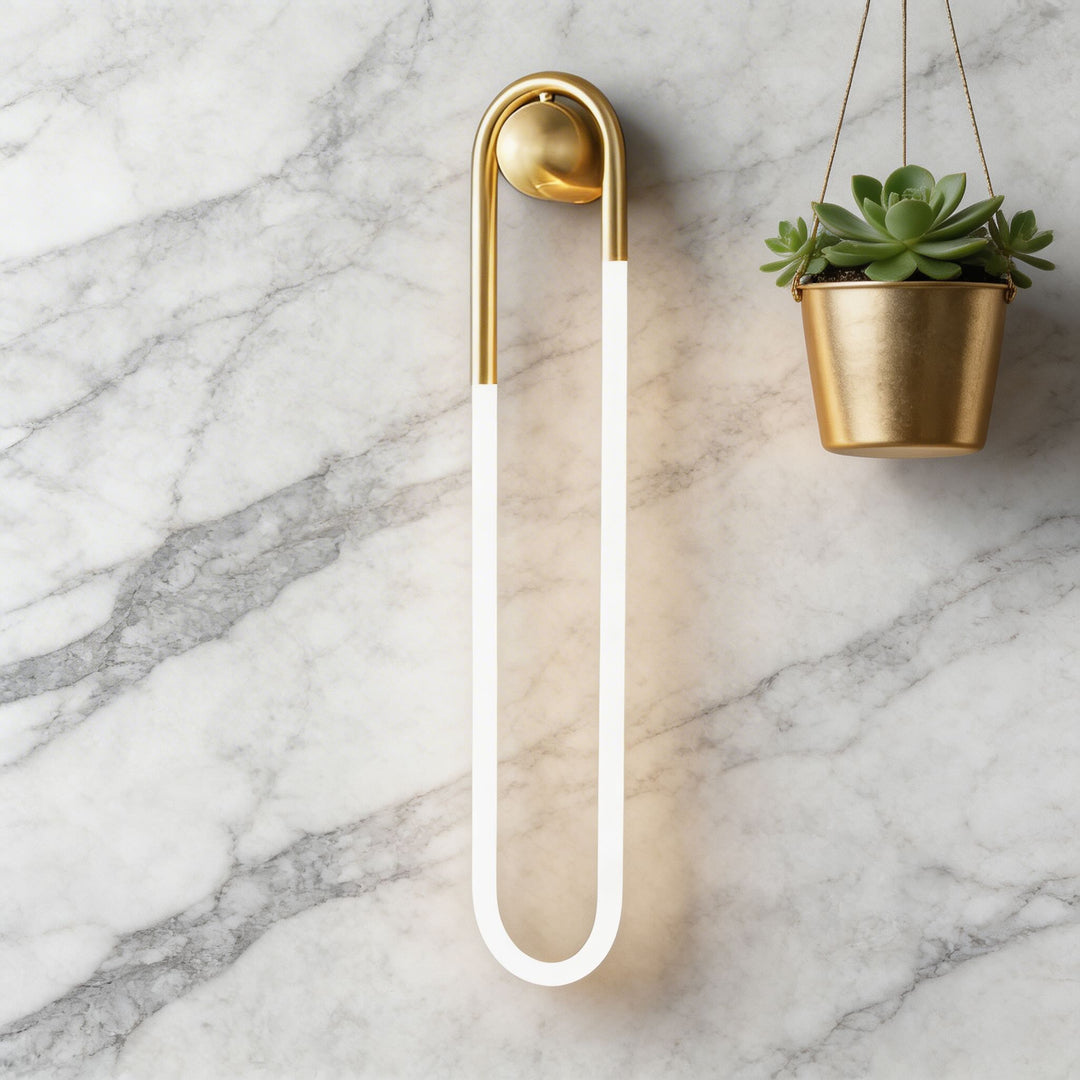 White glowing U-shaped LED wall sconce with brushed gold brass ball mount on marble wall, luxury bathroom wall light Australia