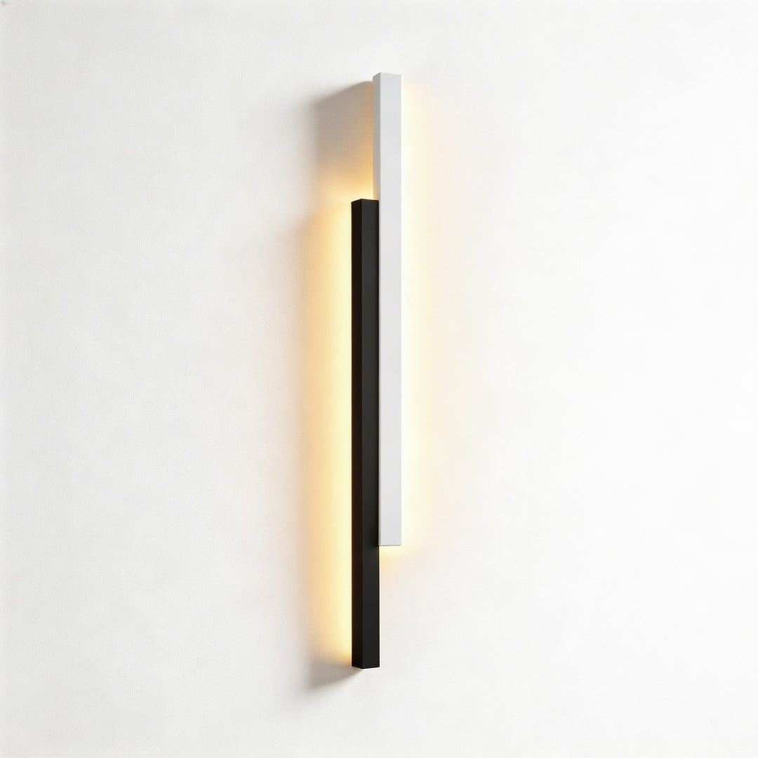 Wall lights in black and white finish with slim linear LED form, modern vertical sconce design with warm backlit glow and clean lines