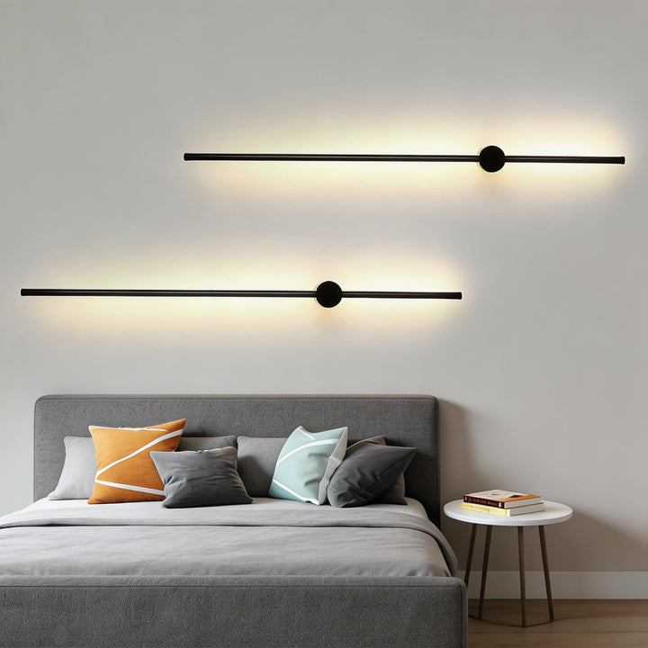 Wall lights in matte black with slim linear LED design, modern bar sconces with round centre detail and soft ambient backlit glow