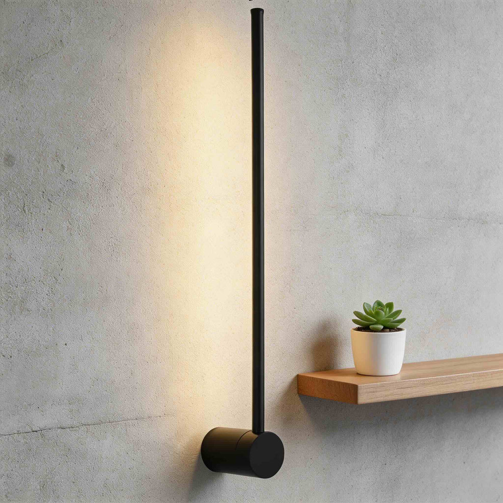 Wall sconce in matte black with slim vertical rod and round base, minimalist LED wall light with warm ambient glow and modern design