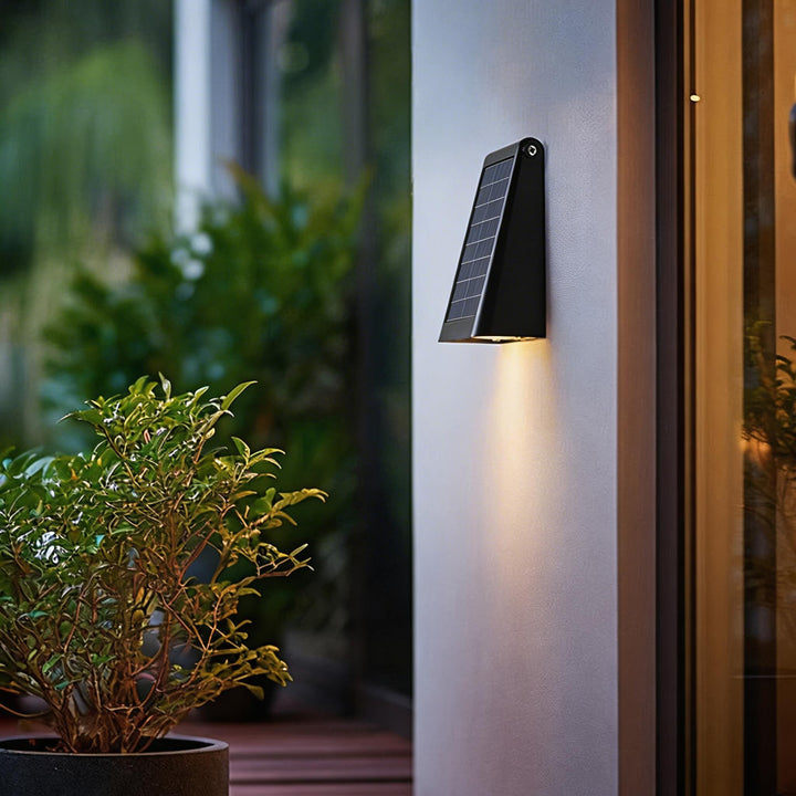 Wall sconces black solar powered LED wall light with slim wedge profile, integrated solar panel and focused downward beam for outdoor use at entryways