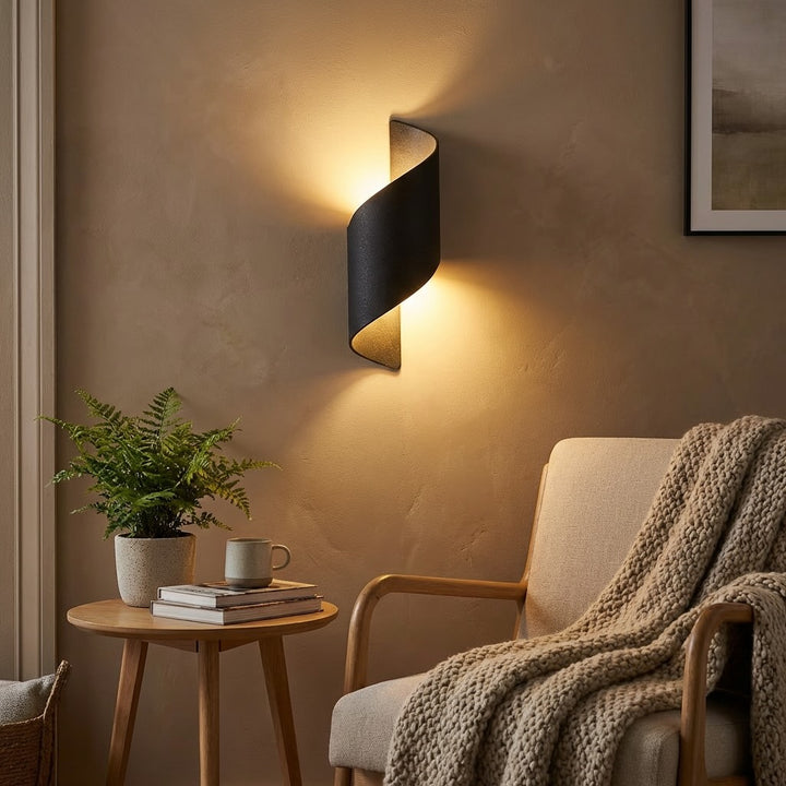 Wall sconce in matte black twisted design, modern wall light with warm ambient glow and sculptural curved silhouette